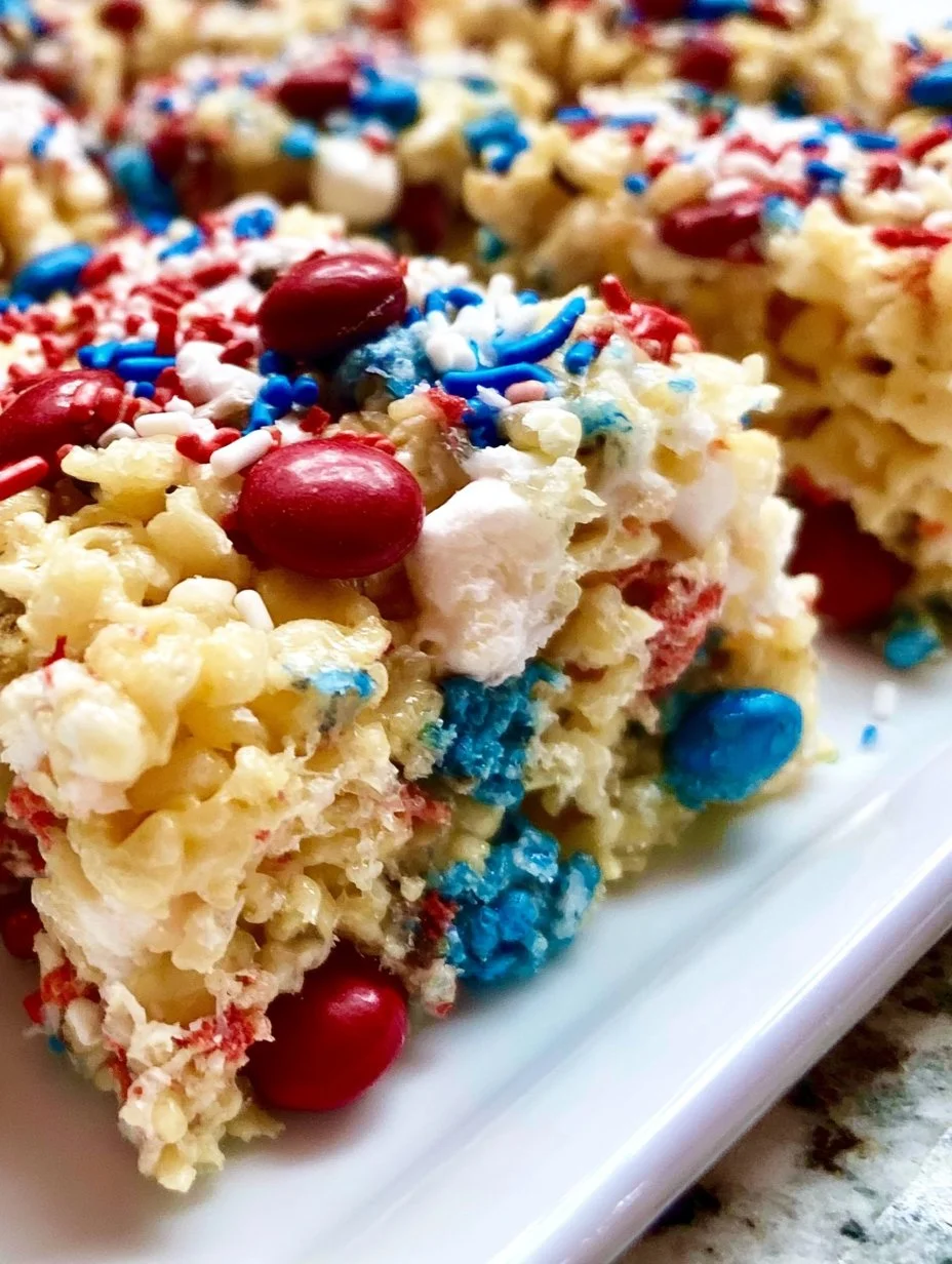 Fourth of July themed Rice Krispies Treats decorated with red, white, and blue sprinkles.