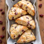 Cranberry scones with vanilla cream glaze in a baking tray