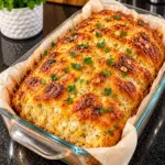 Golden cottage cheese garlic cheddar bread in a clear glass loaf pan