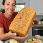 Golden sesame-topped 3-Ingredient Chickpea Flour Bread held in a bright home kitchen